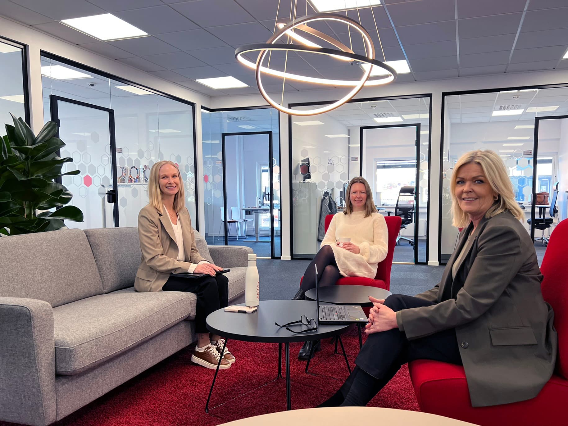 Three Ability colleagues in conversation in the office social zone