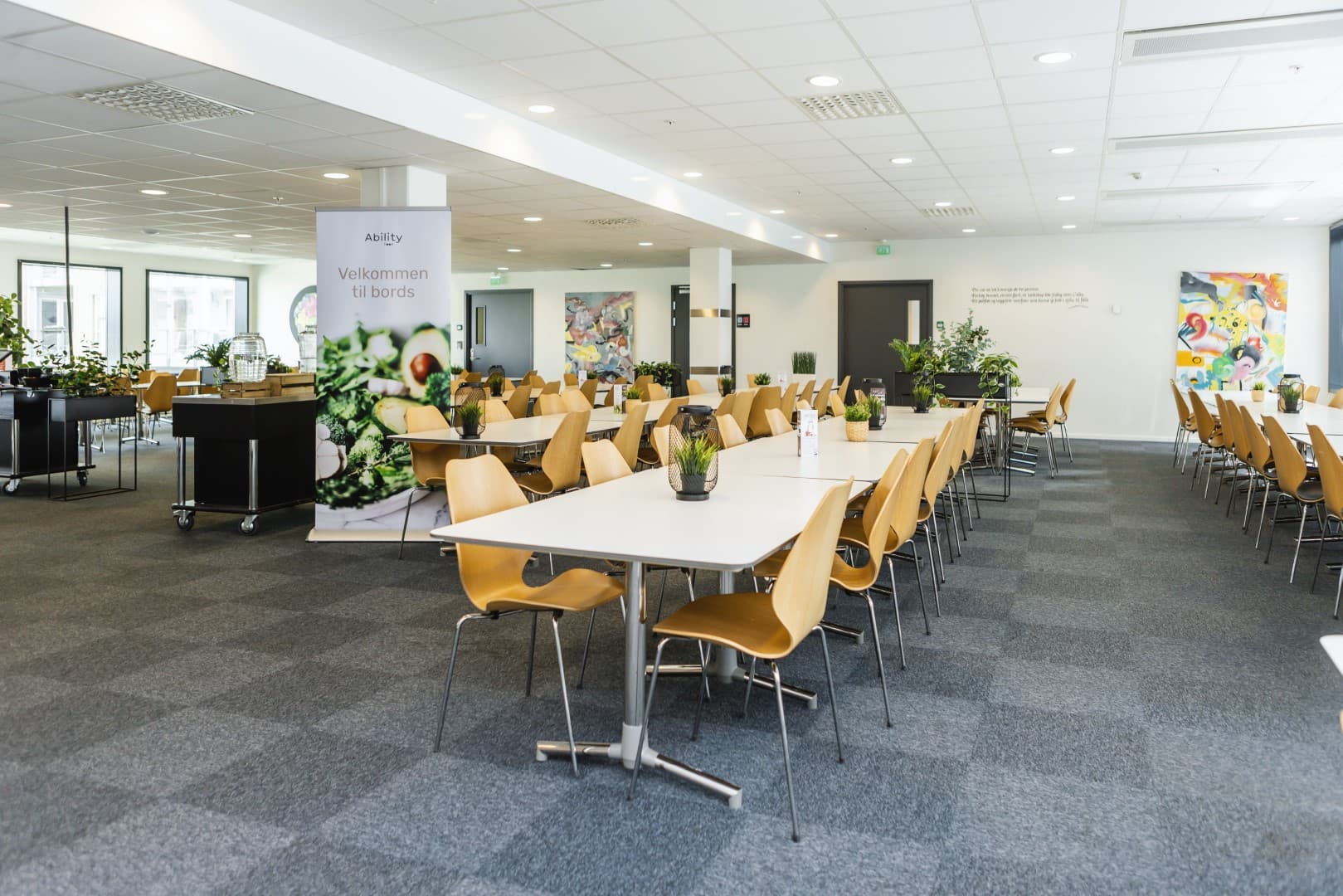 Kantinesal dekket til lunsj, med «Velkommen til bords»-banner fra Ability