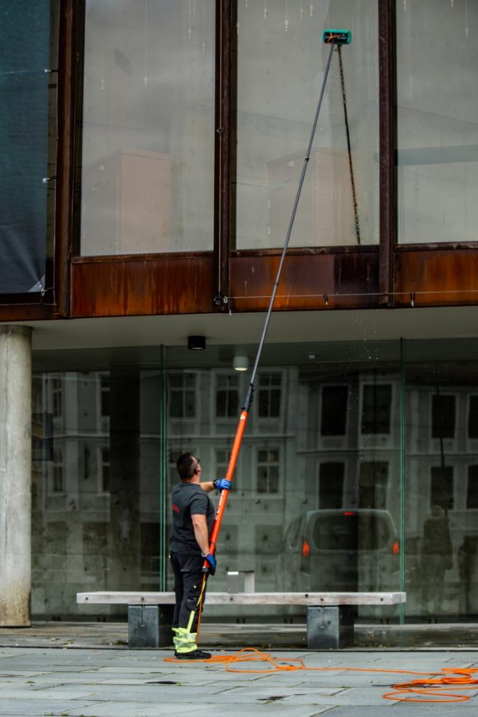 Mann vasker vinduer utvendig 3-4 meter opp med Ionic vindusvask.