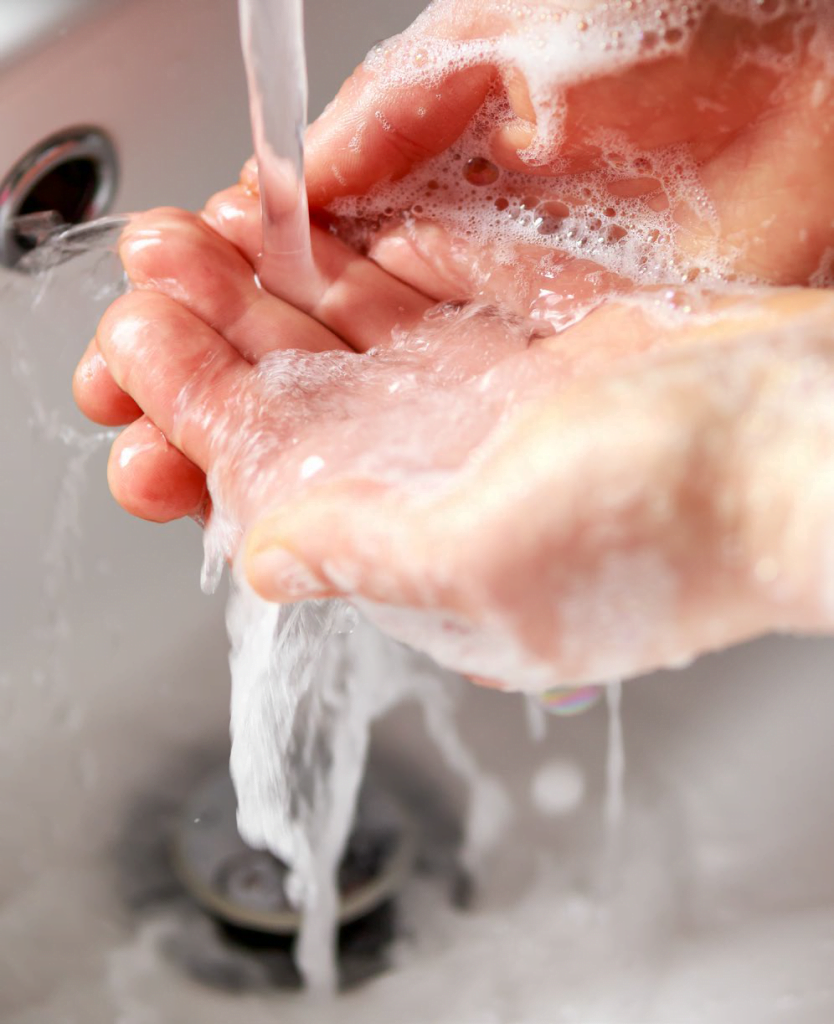 Vaske hender med såpe i rennende vann