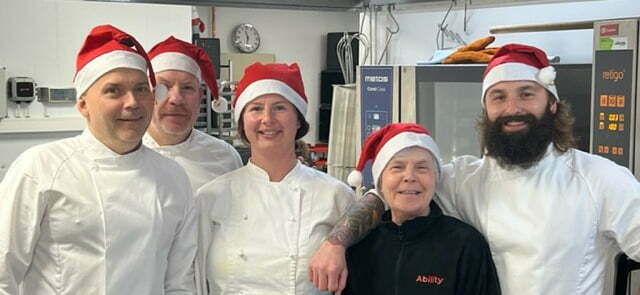 Bilde av noen av de som jobber ved produksjonskjøkkenet i Stavanger med nisseluer på.