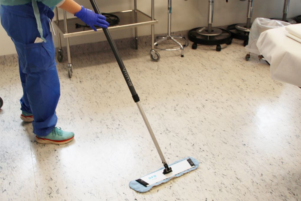 En renholder mopper gulvet på en operasjonsstue med Viima.