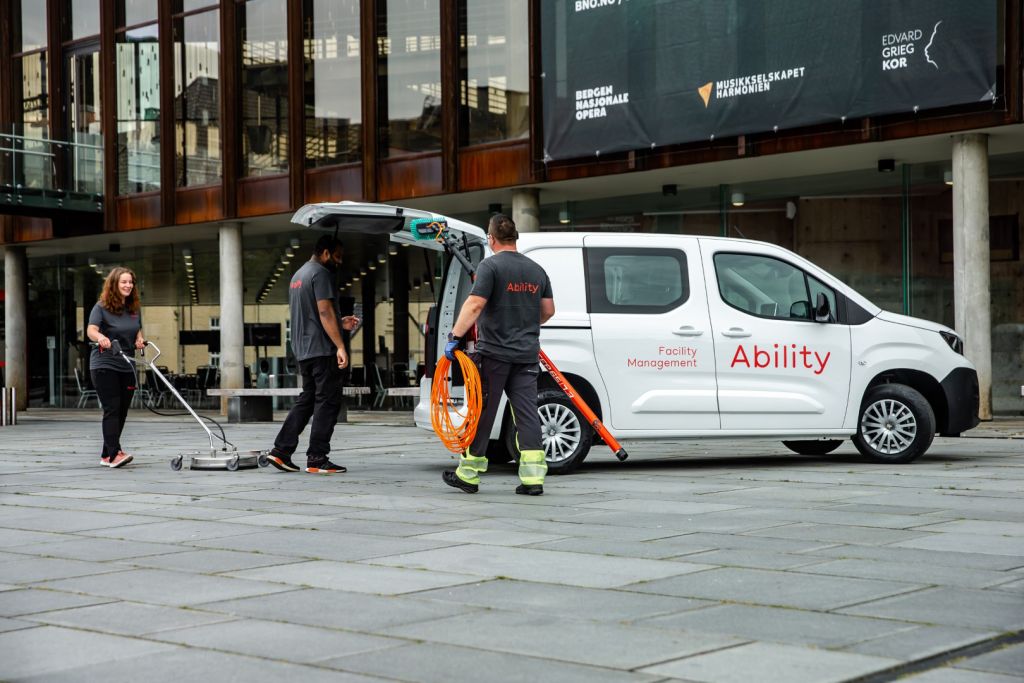 3 Ability-medarbeidere laster inn utstyr i en varebil